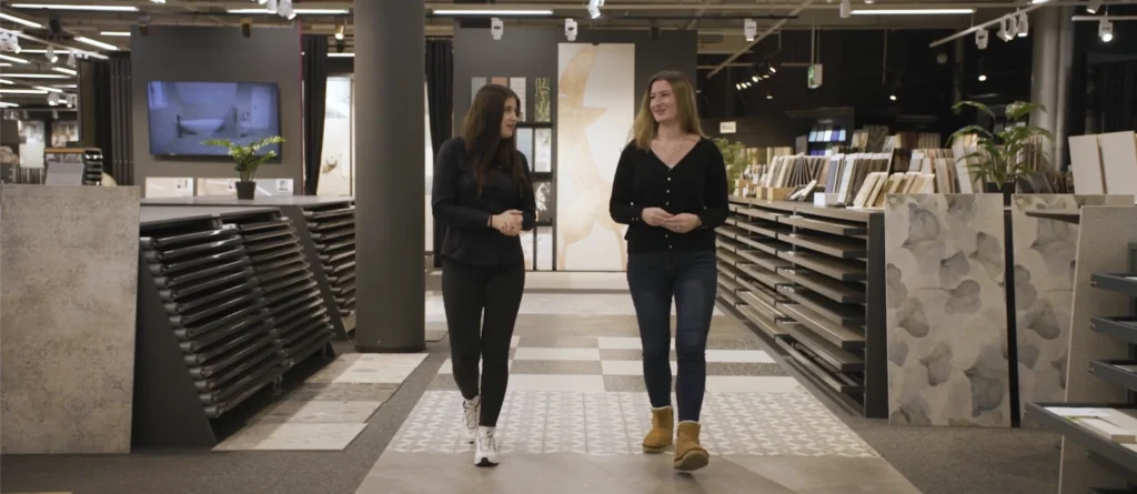 Zwei Auszubildende von artfliesen laufen einen Gang entlang